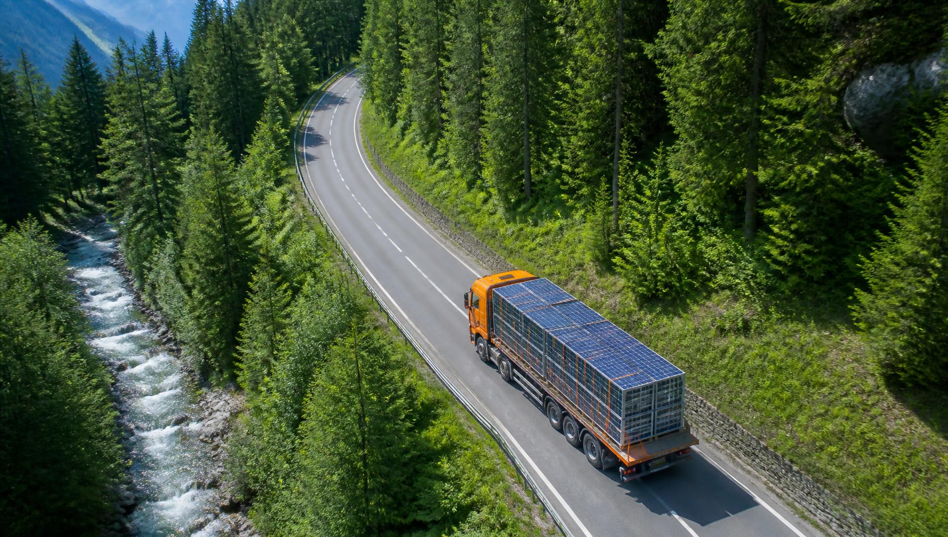 LKW mit gestapelten Photovoltaik-Modulen auf einer Tiroler Bergstraße